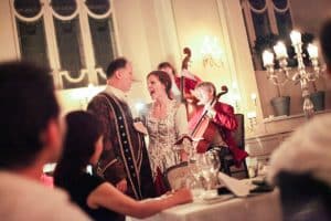 Mozart Dinner, Mozart Diner Concert in Salzburg Sängerin und Sänger in historischen Kostümen bei einer Barockaufführung mit Musikensemble in festlichem Kerzenschein.